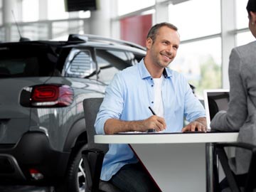 Ein Mann unterzeichnet den Kaufvertrag beim Autoankauf Elmschenhagen